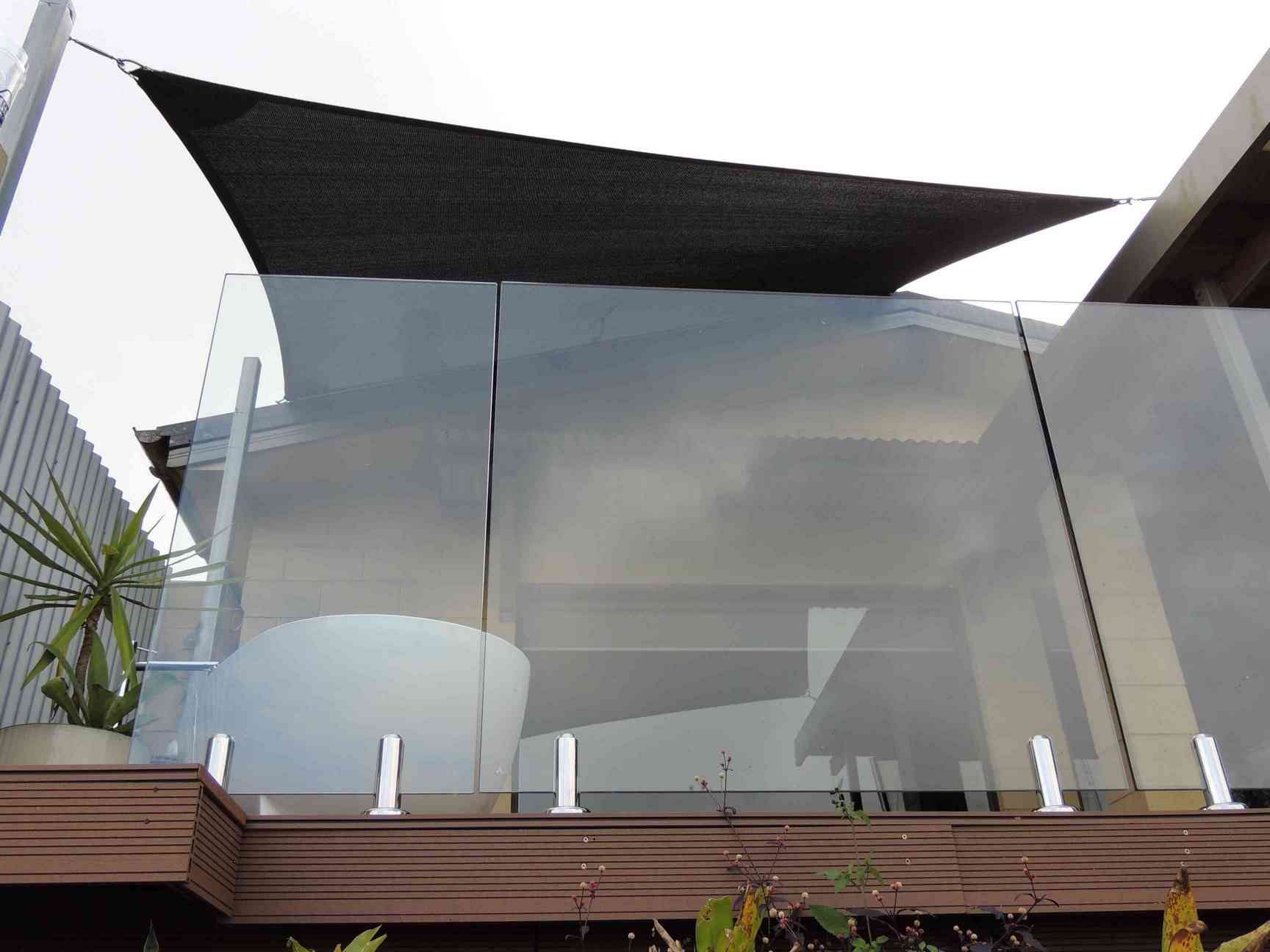 A Balcony With A Glass Railing And A Black Umbrella — Style Shades Installation In Mareeba, QLD