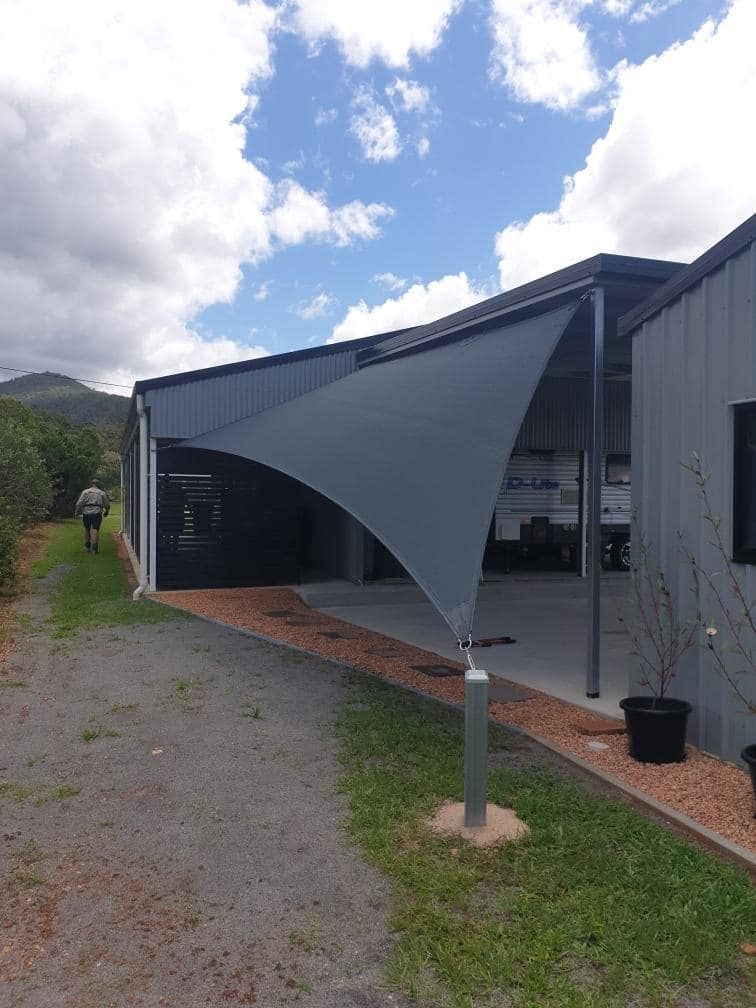 A Large Shade Sail is Sitting in Front of a Building — Style Shades Installation In Cooktown, QLD