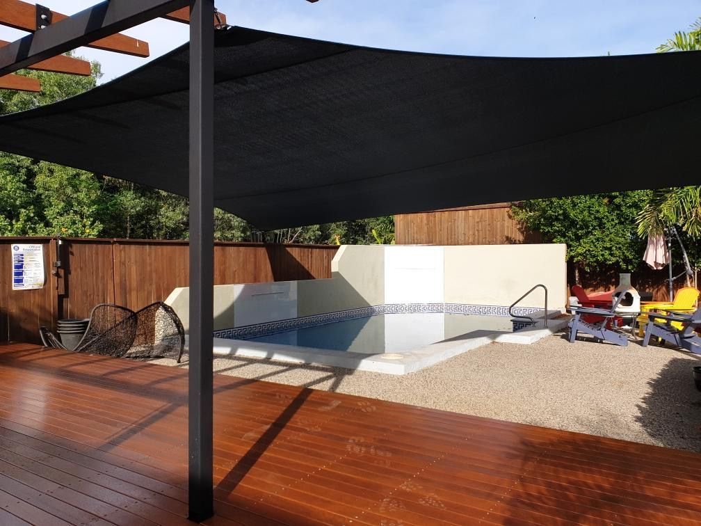 A Swimming Pool With a Black Umbrella Over It — Style Shades Installation In Ravenshoe, QLD