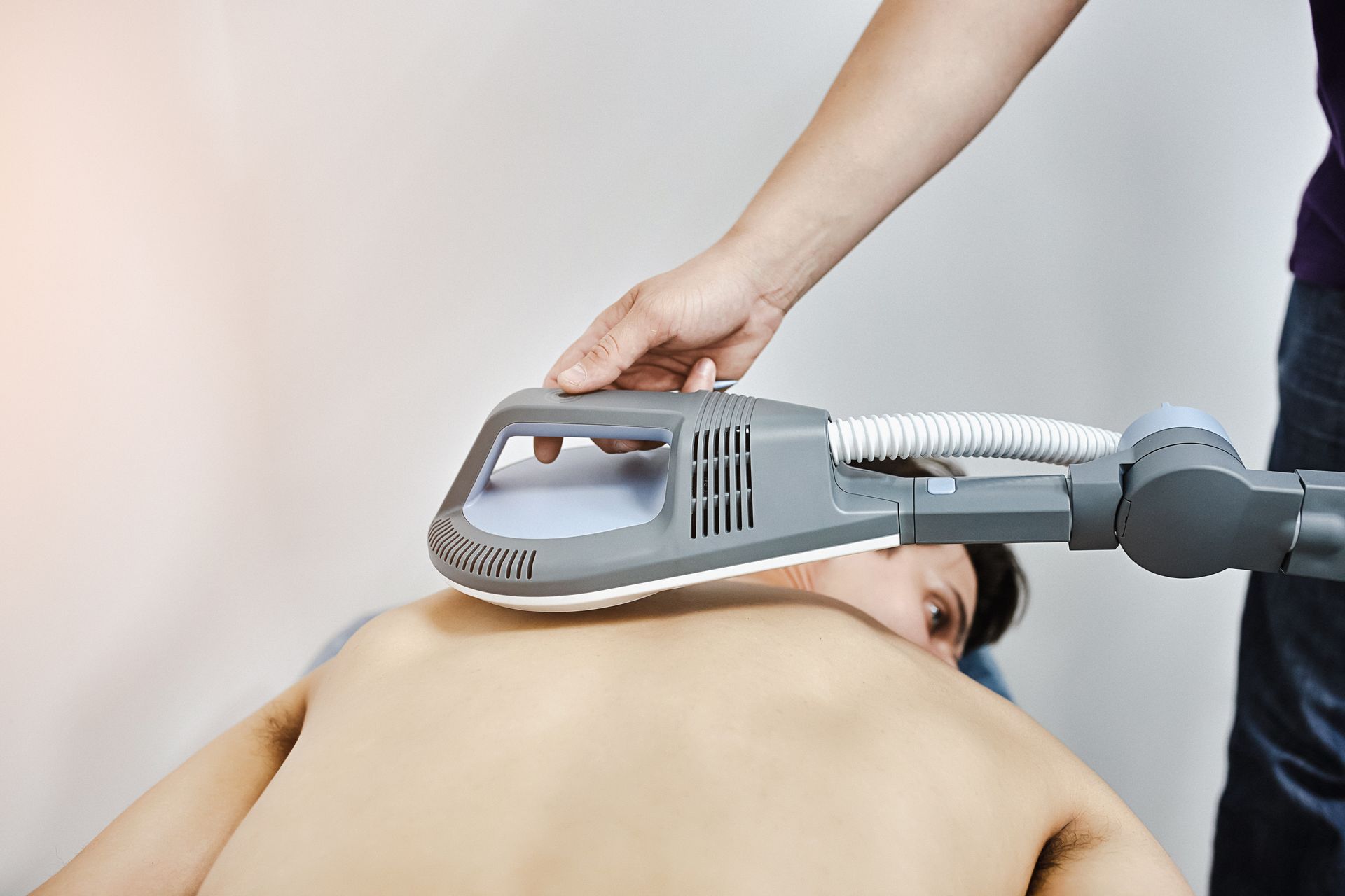Ein Mann erhält mit einem speziellen Gerät eine Magnetfeldtherapie
