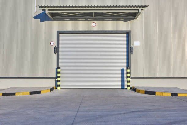 Loading dock door closed, gray corrugated metal building. 