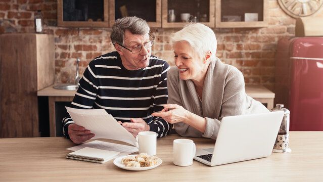 Senior couple reviewing medical documents at a wooden table