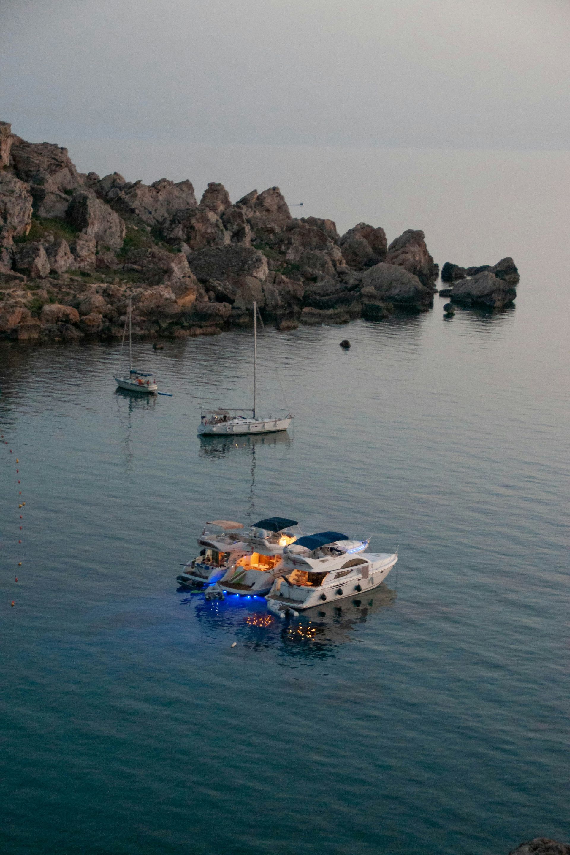 A group of boats are floating on top of a body of water.
