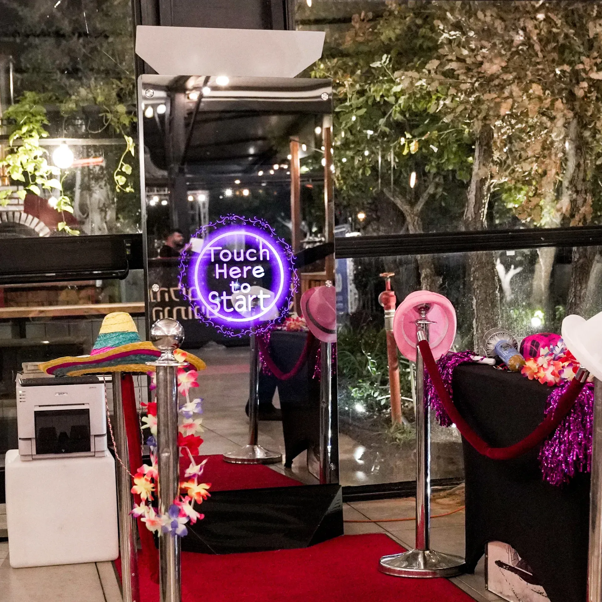 A photo booth with a sign that says touch here to start