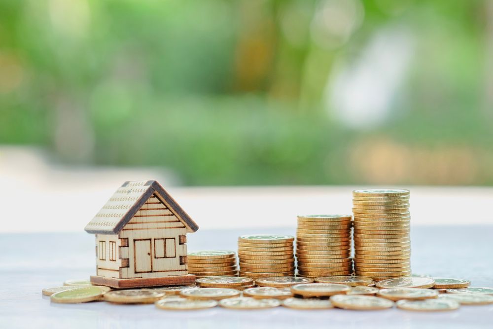 Wooden House Model Beside Increasing Stacks of Gold Coins — Peterson Property Valuations Brisbane in Caloundra West, QLD
