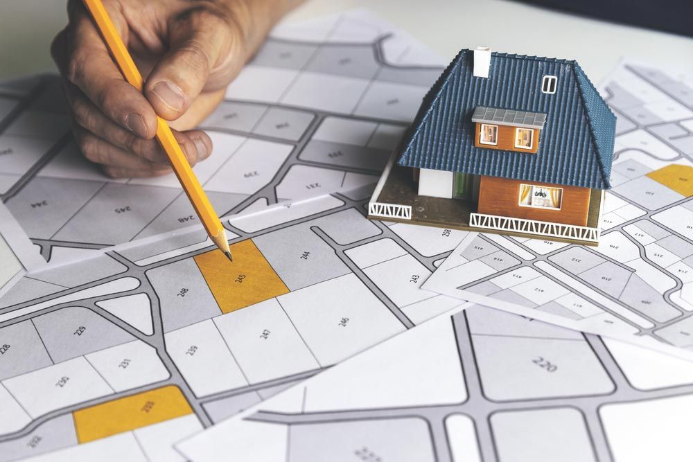 Hand Pointing to a Plot of Land on a Map — Peterson Property Valuations Brisbane in Caloundra West, QLD