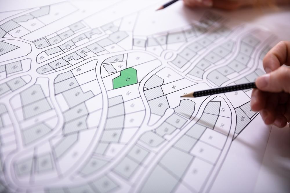 Hands Pointing to a Detailed Land Map — Peterson Property Valuations Brisbane in Caloundra West, QLD