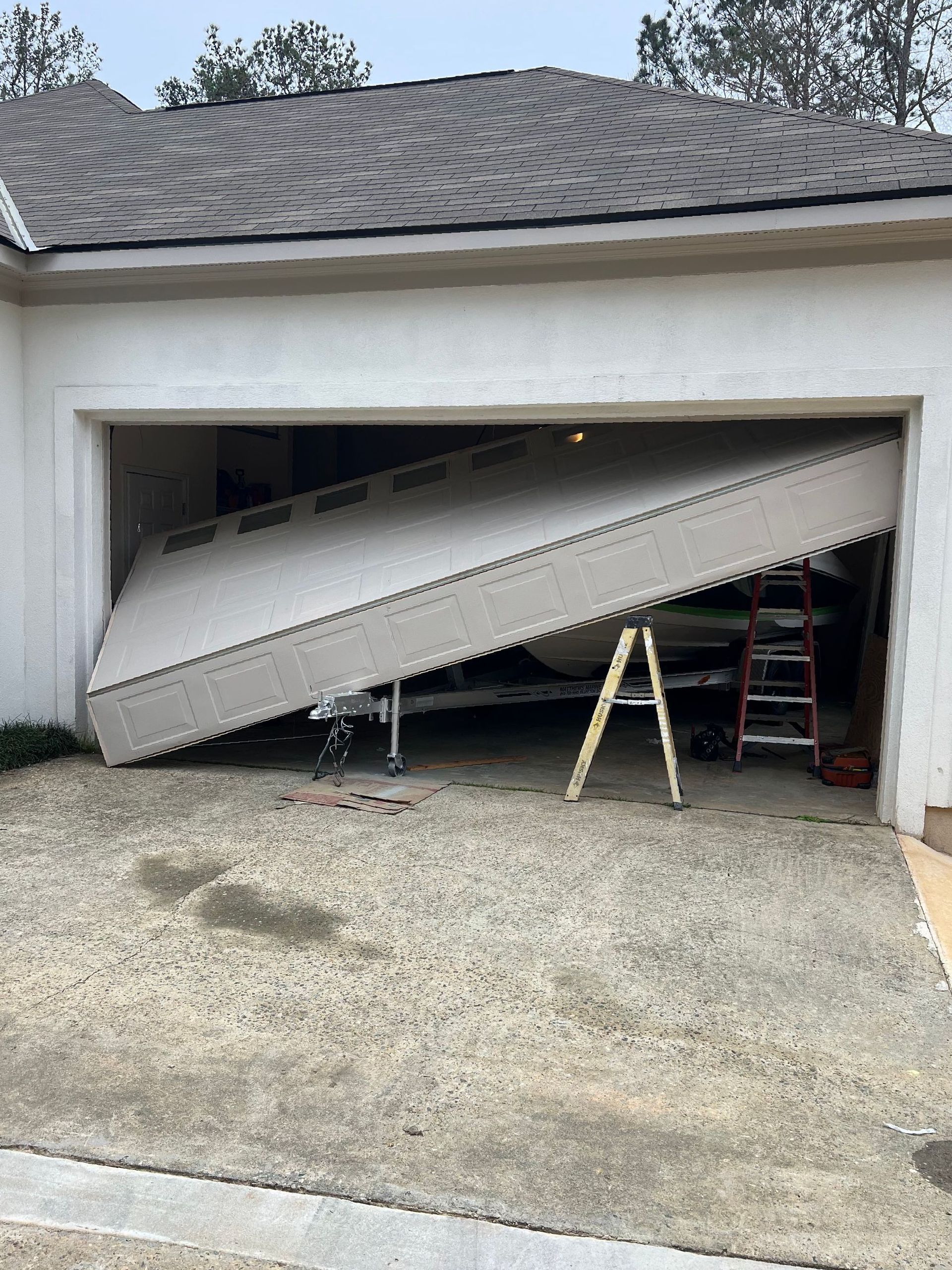A garage door that has fallen off of the frame. Before picture