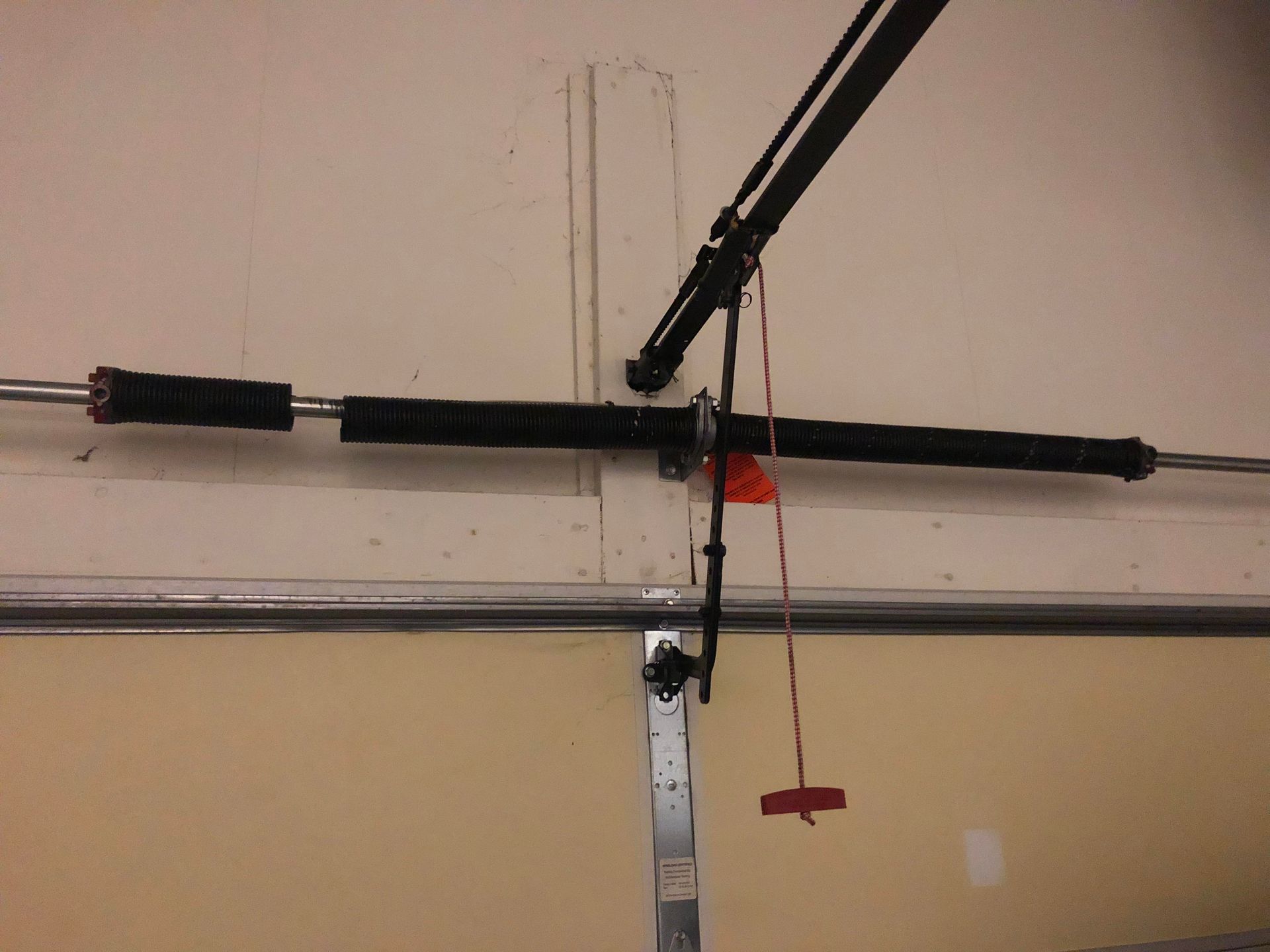 A close up of a broken garage door spring in a garage