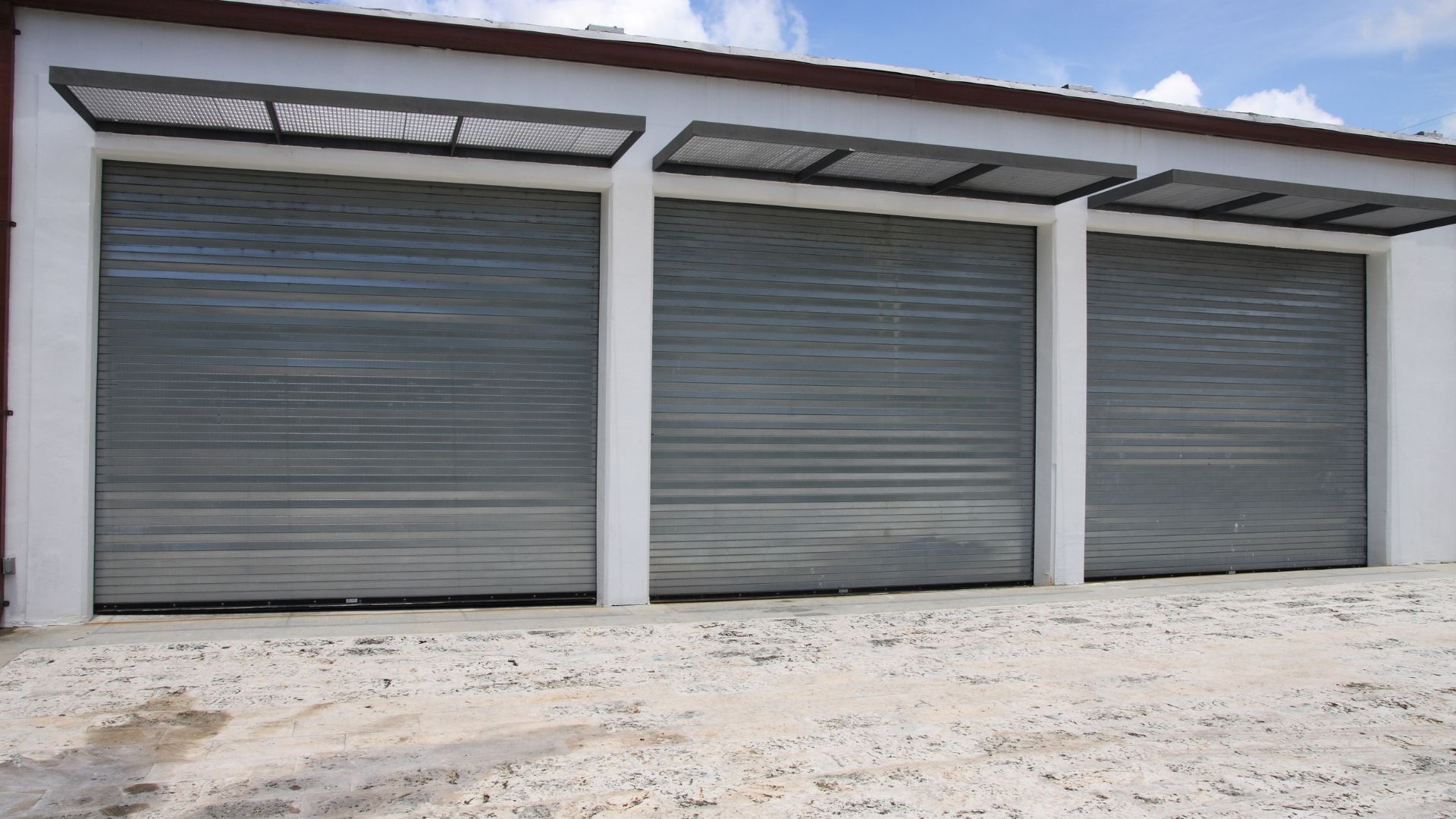 A row of garage doors with a canopy on top of them