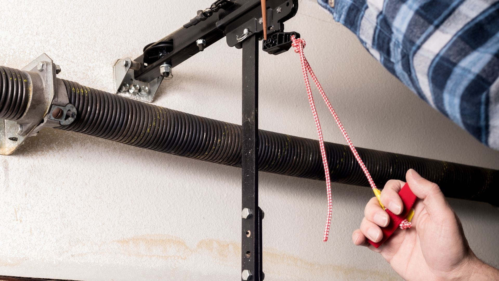 A person is fixing a garage door spring r.