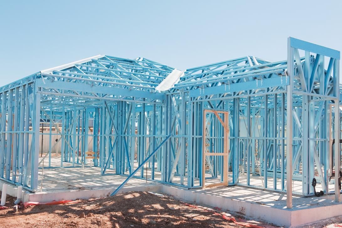 A House Is Being Built with A Blue Metal Frame — Jonobilt in Wallsend, NSW
