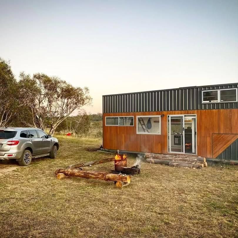 A Car Is Parked in Front of A Tiny House with A Fire Pit in Front of It — Jonobilt in Charlestown, NSW