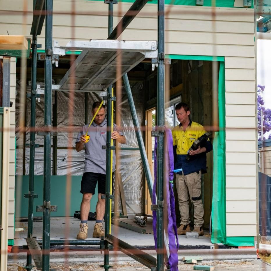 A Man Standing on A Scaffolding Holding a Tape Measure — Jonobilt in Merewether, NSW