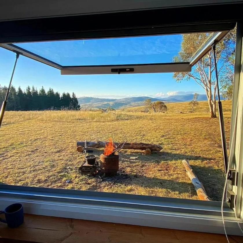 A Window with A View of A Field and A Fire Pit — Jonobilt in Mayfield, NSW