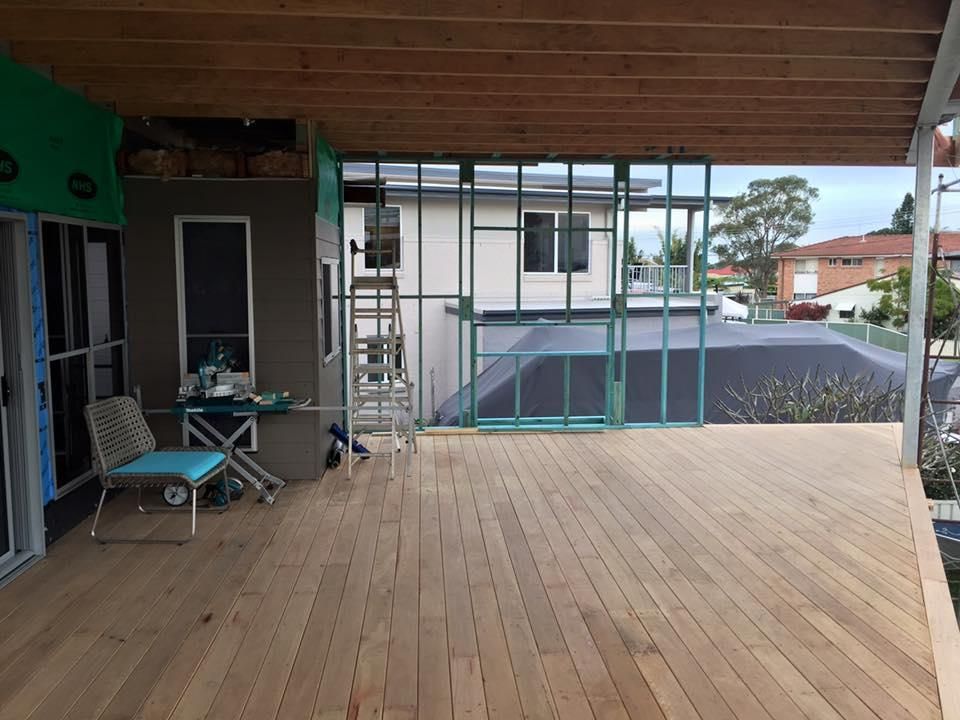 A Large Wooden Deck with A Chair and A Table on It — Jonobilt in New Lambton, NSW