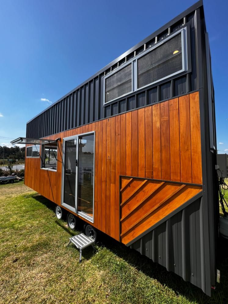 A Tiny House Is Sitting on Top of A Lush Green Field — Jonobilt in Bolwarra, NSW