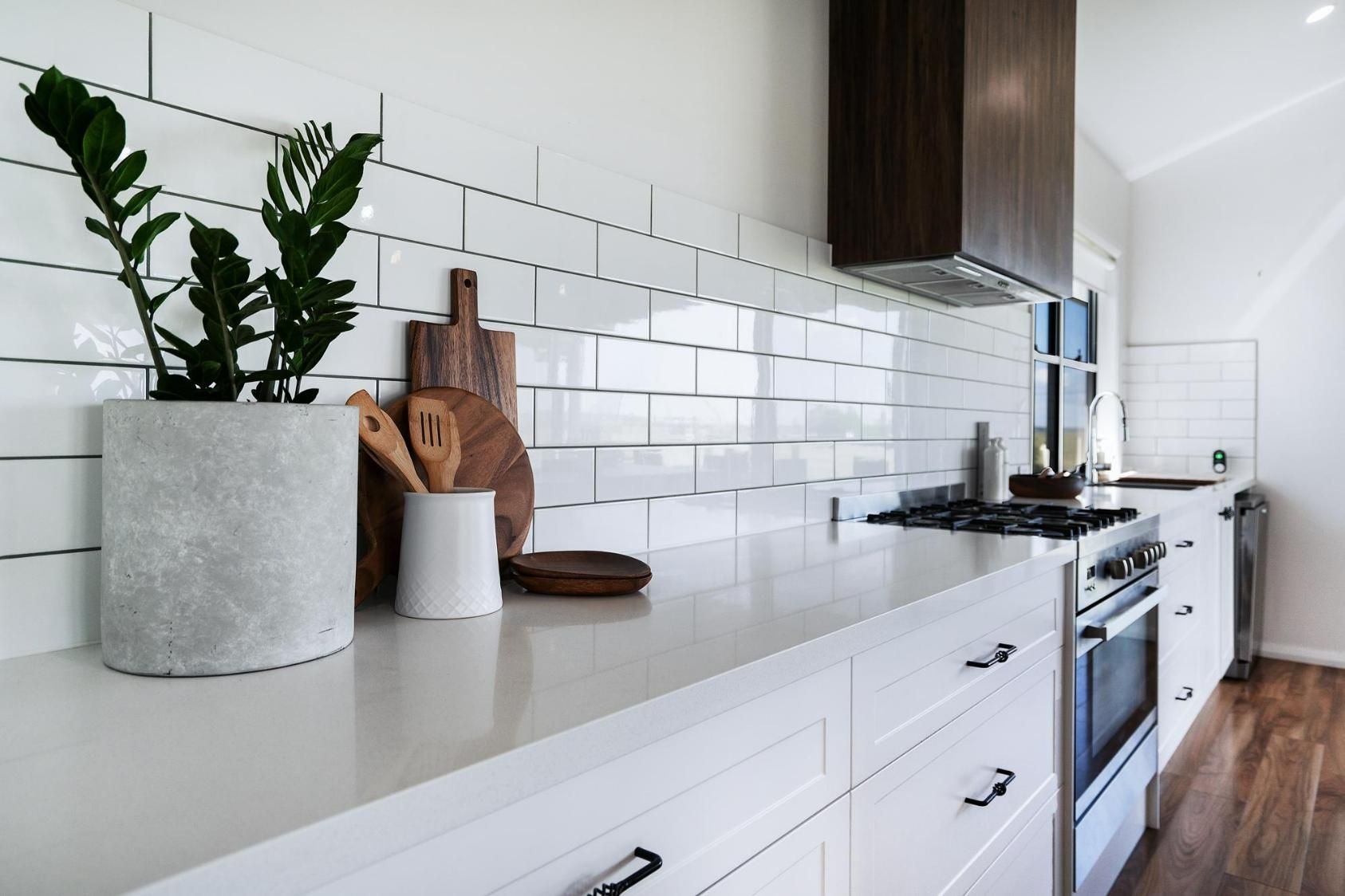 A Kitchen with White Cabinets and A Potted Plant on The Counter — Jonobilt in Newcastle, NSW