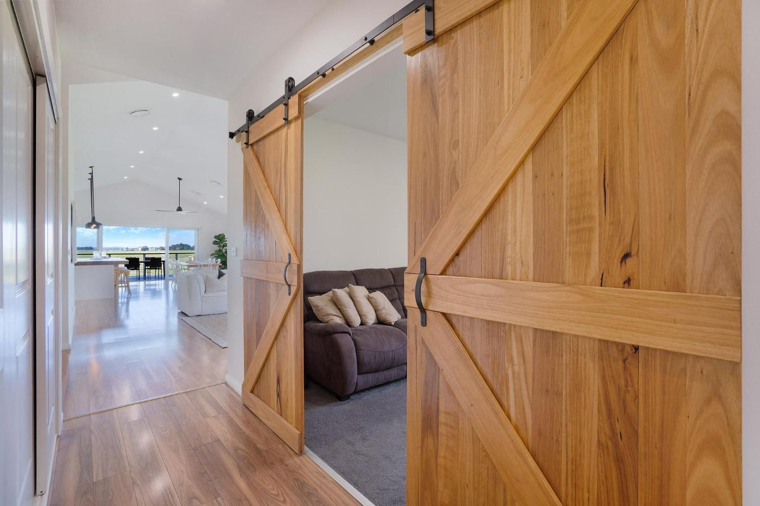 A Hallway with Sliding Barn Doors Leading to A Living Room — Jonobilt in Valentine, NSW