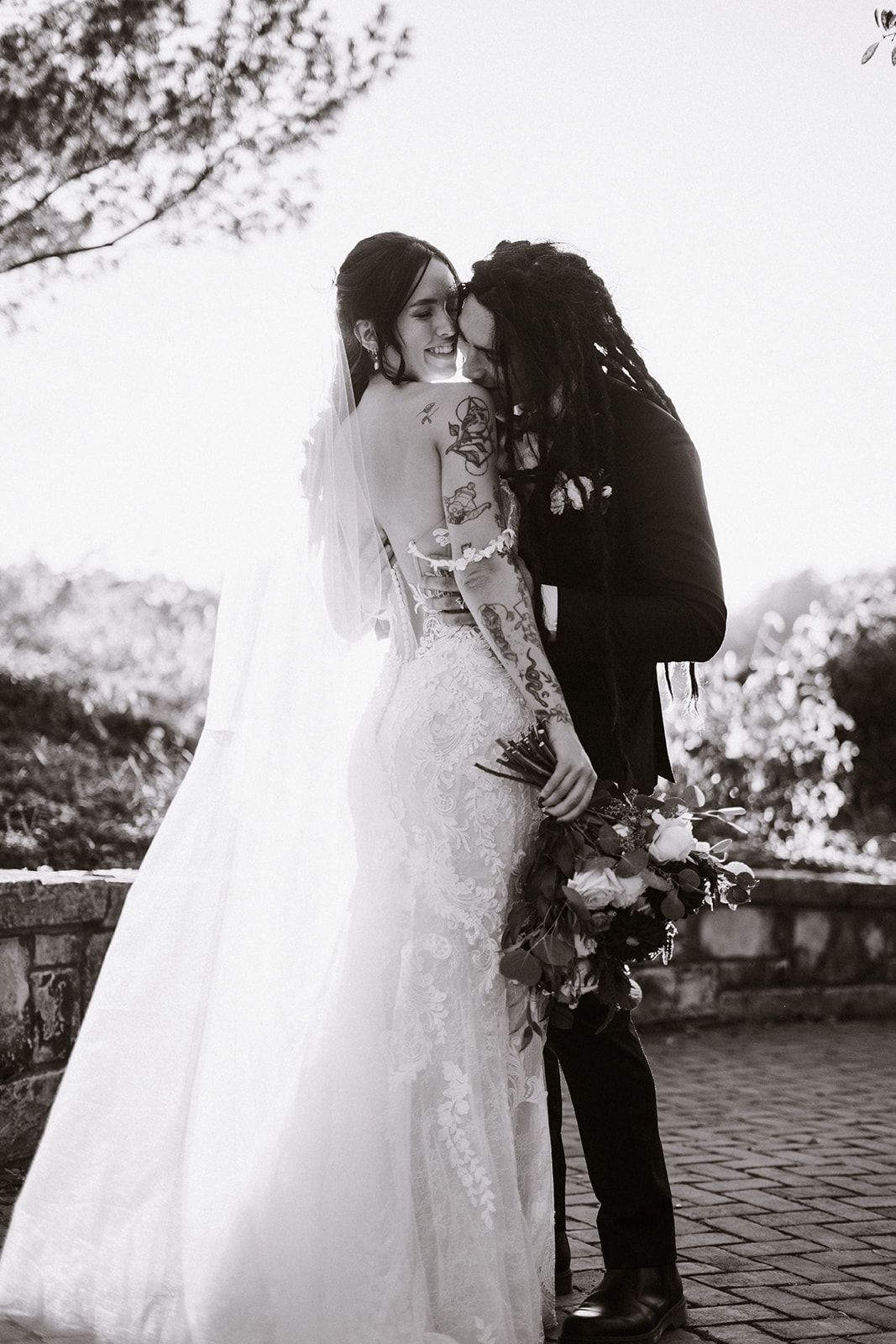 A bride and groom are kissing in a black and white photo.