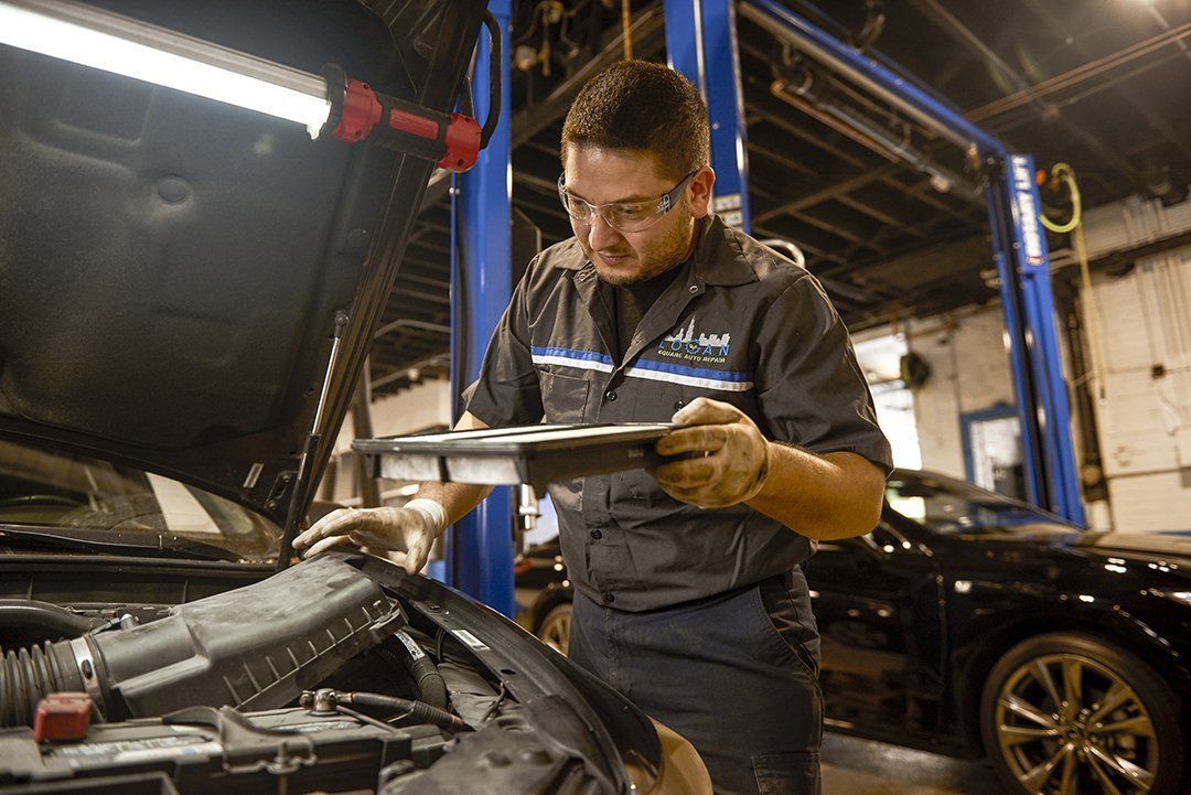 Mechanic inspecting a car engine in a garage, holding a clipboard under bright shop lights