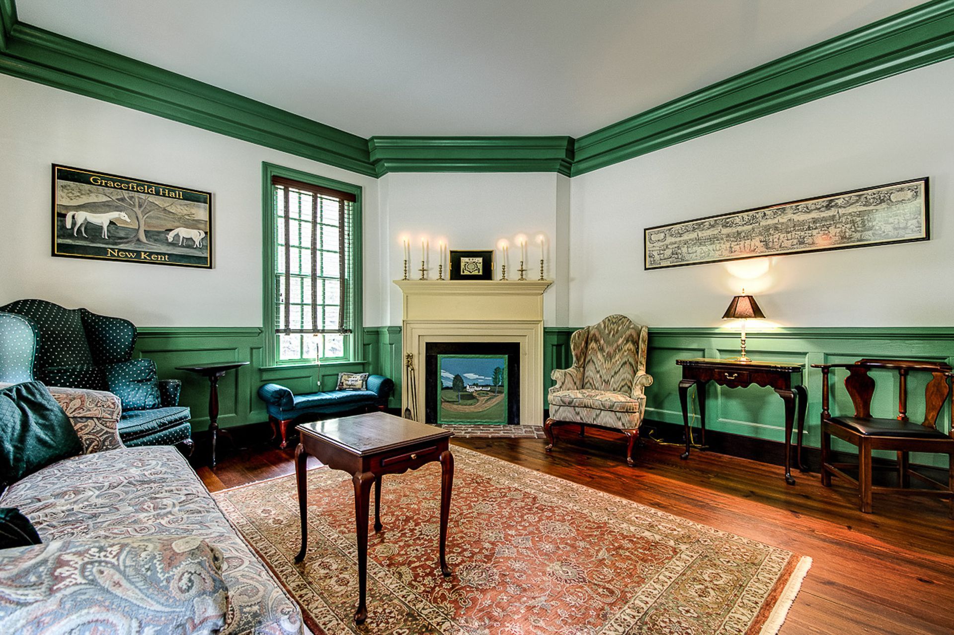 A living room with green walls and a fireplace