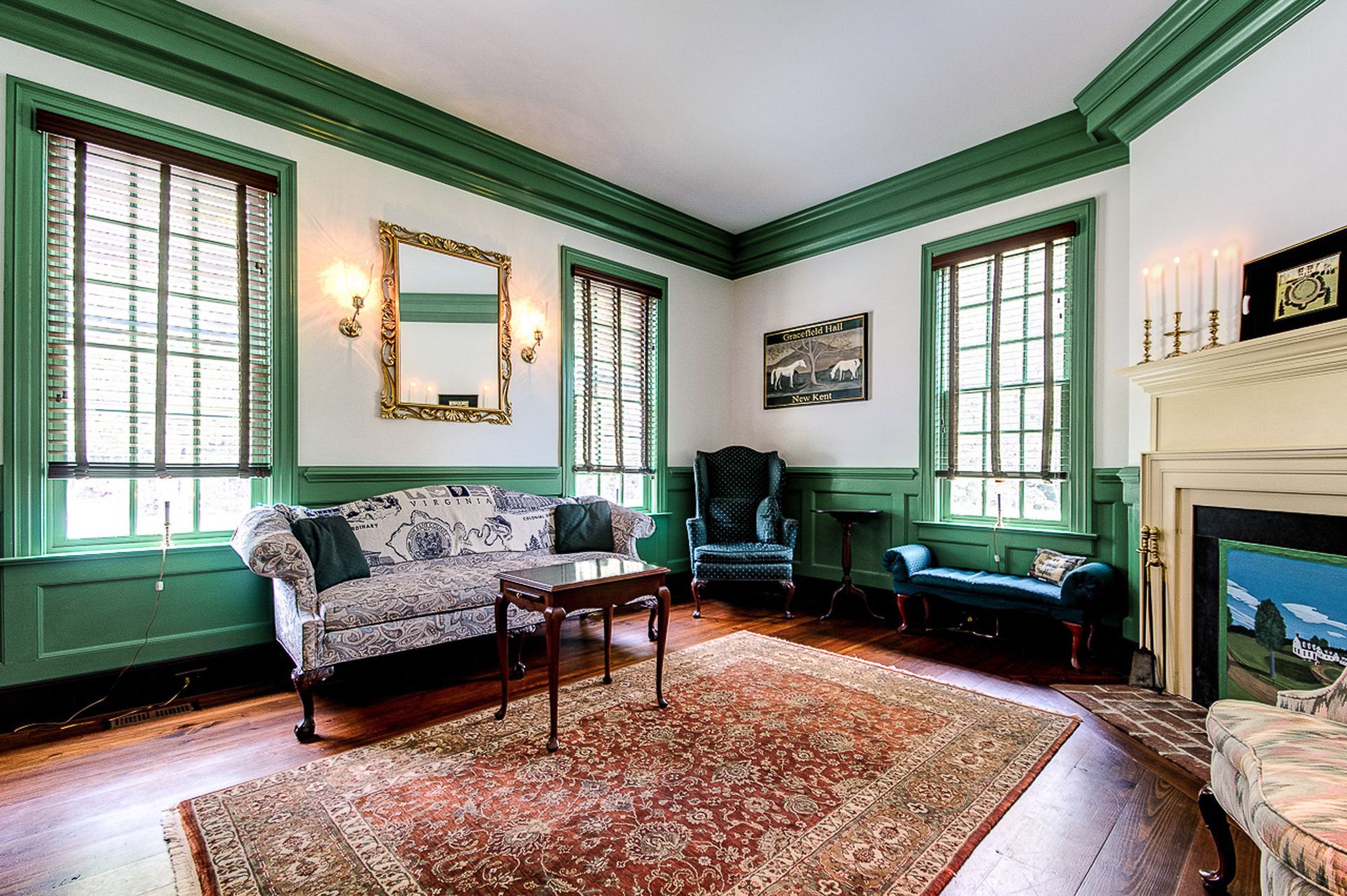 A living room with green walls and a fireplace