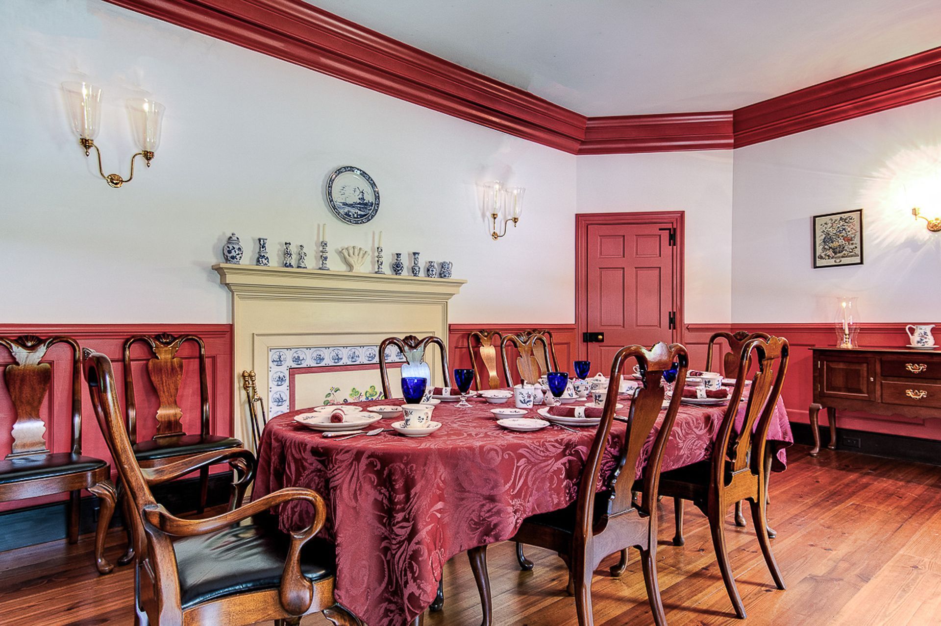 A dining room with a round table and chairs and a fireplace.