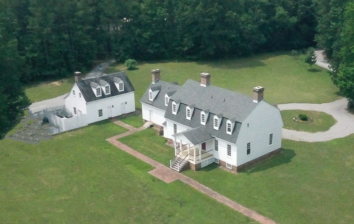 An aerial view of a large white house surrounded by trees