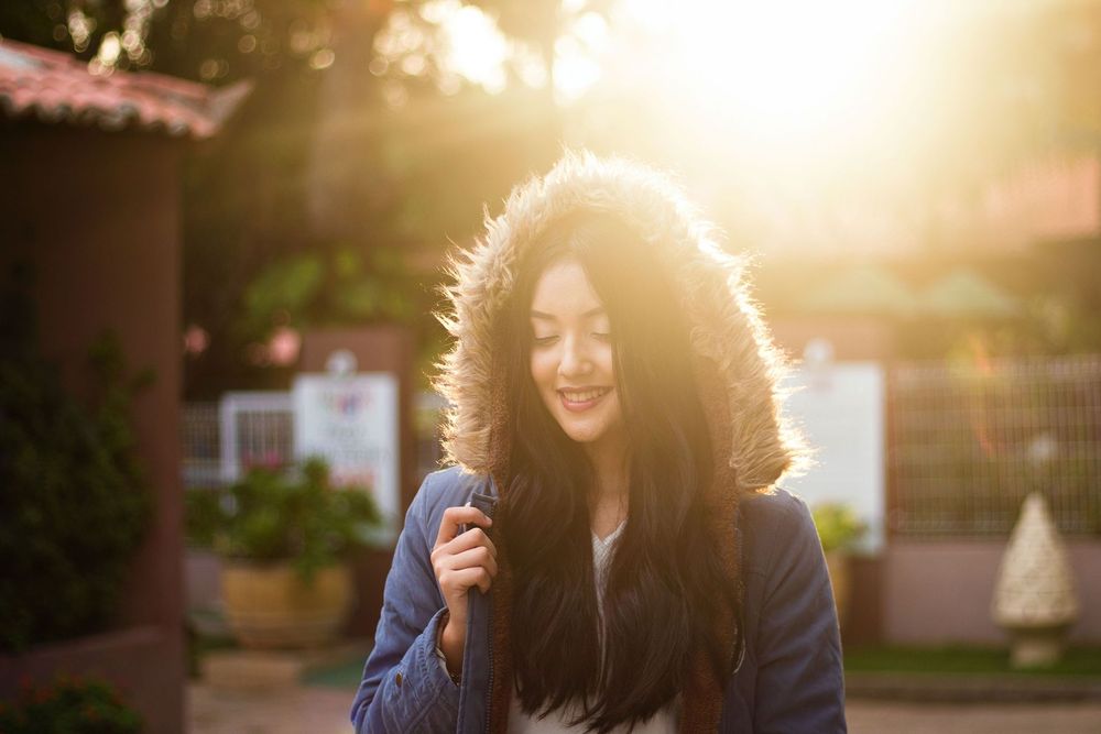 Smiling woman in warm sunlight, relaxed and back to her day