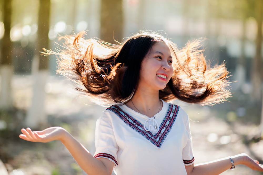 Woman tossing her hair and smiling, glowing before a big event