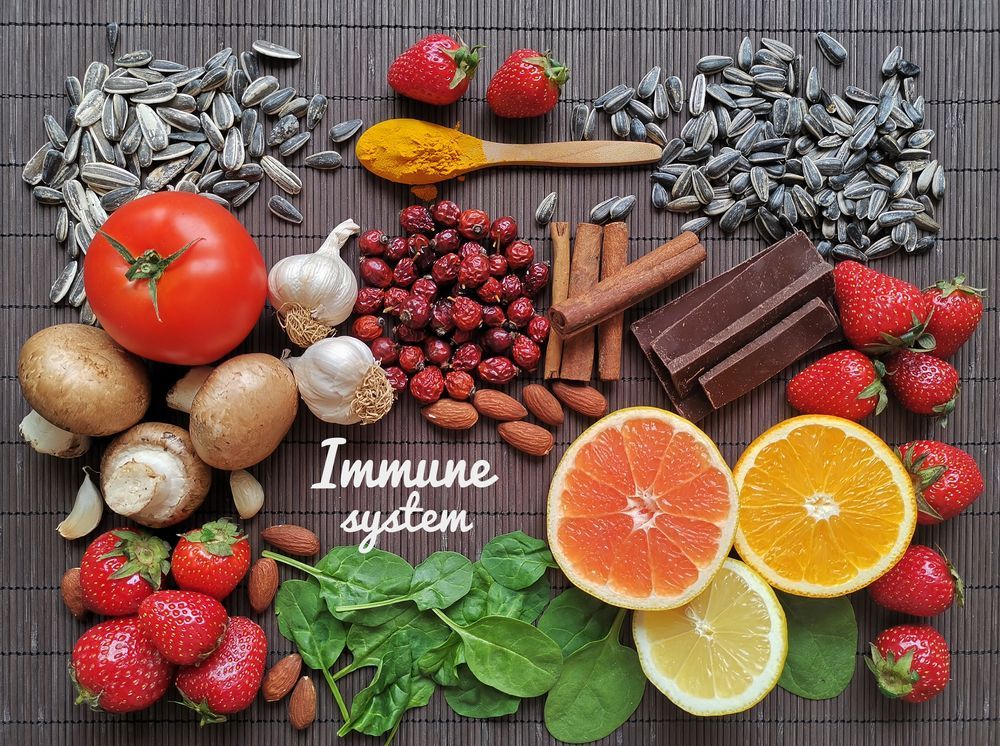 A variety of fruits and vegetables are laid out on a bamboo mat.