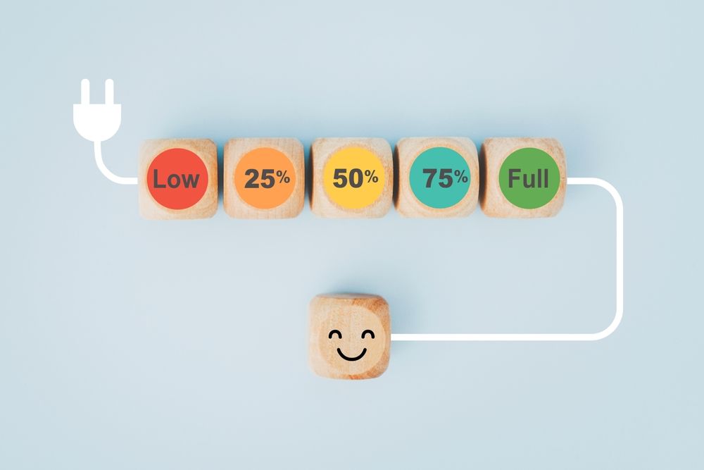 A wooden block with a face on it is connected to a plug.