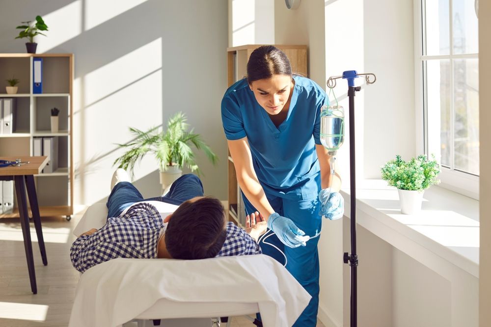 A nurse is giving an iv to a patient in a hospital bed.