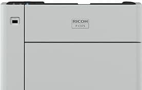 Close-up of a gray Ricoh copier front panel with logo and paper tray edge visible