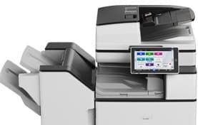 Modern office copier with touchscreen control panel and paper trays open