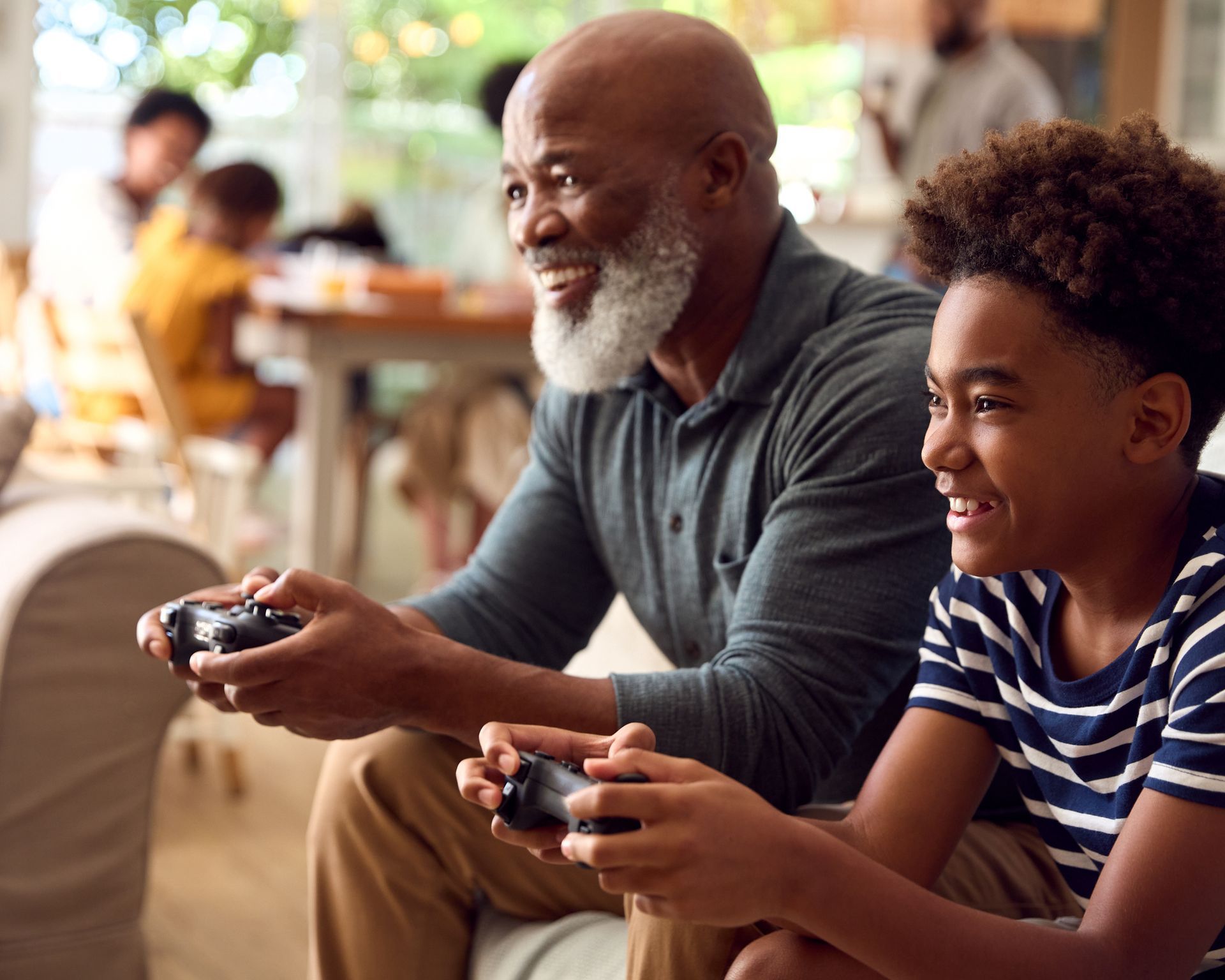 A man and a boy are sitting on a couch playing a video game.