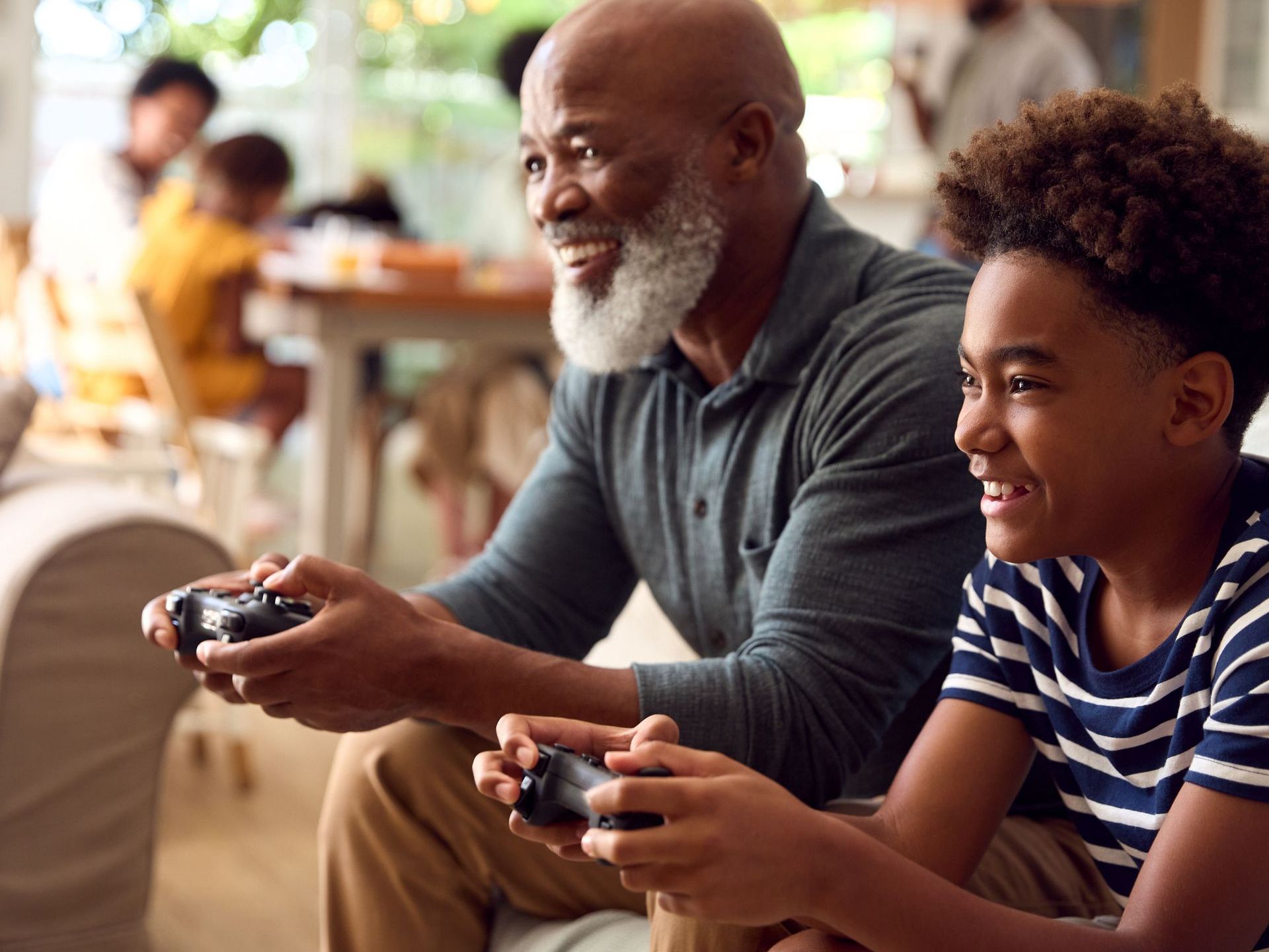 An elderly man and a young boy are playing a video game together.