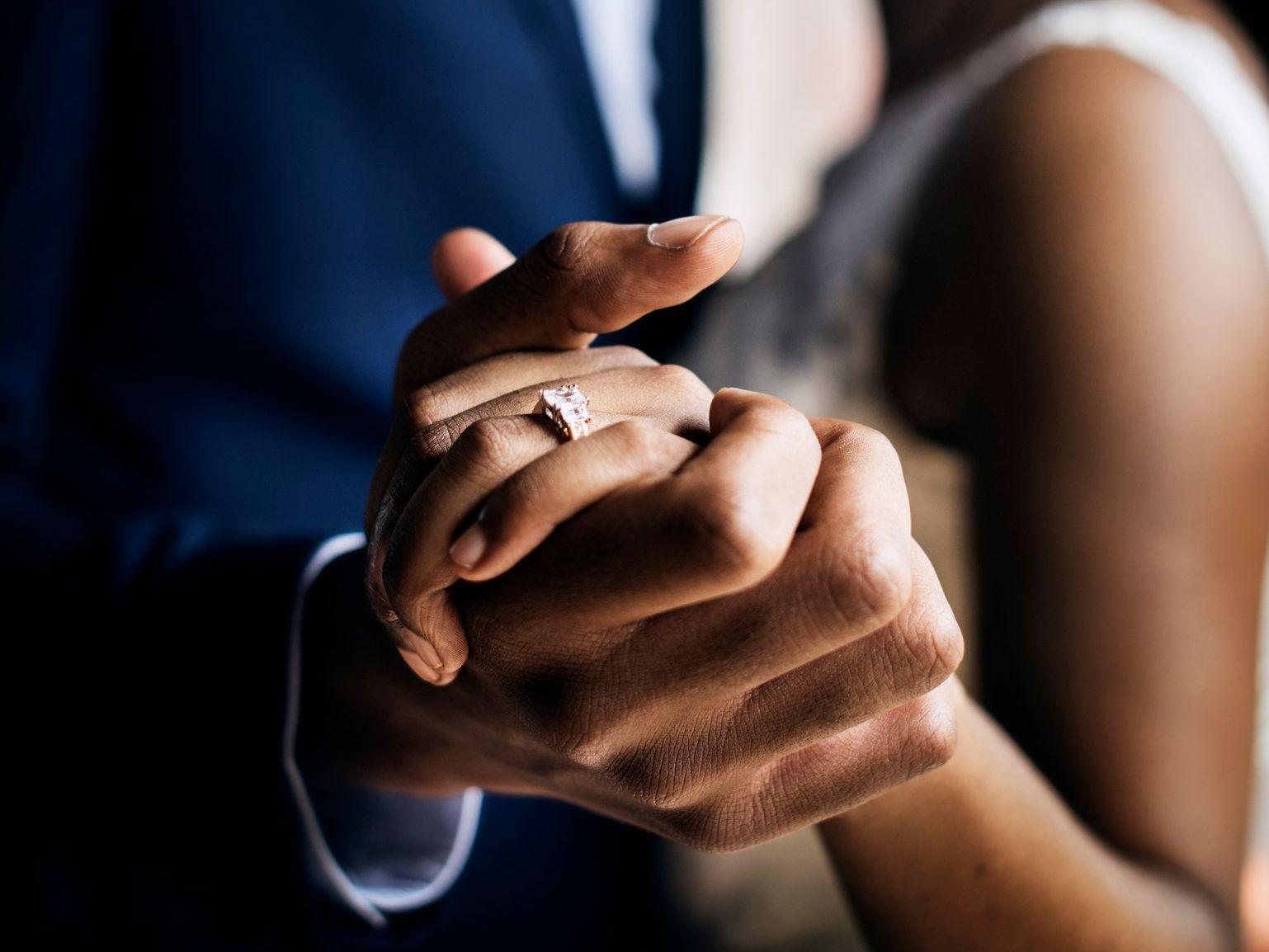 A bride and groom are holding hands while dancing at their wedding.