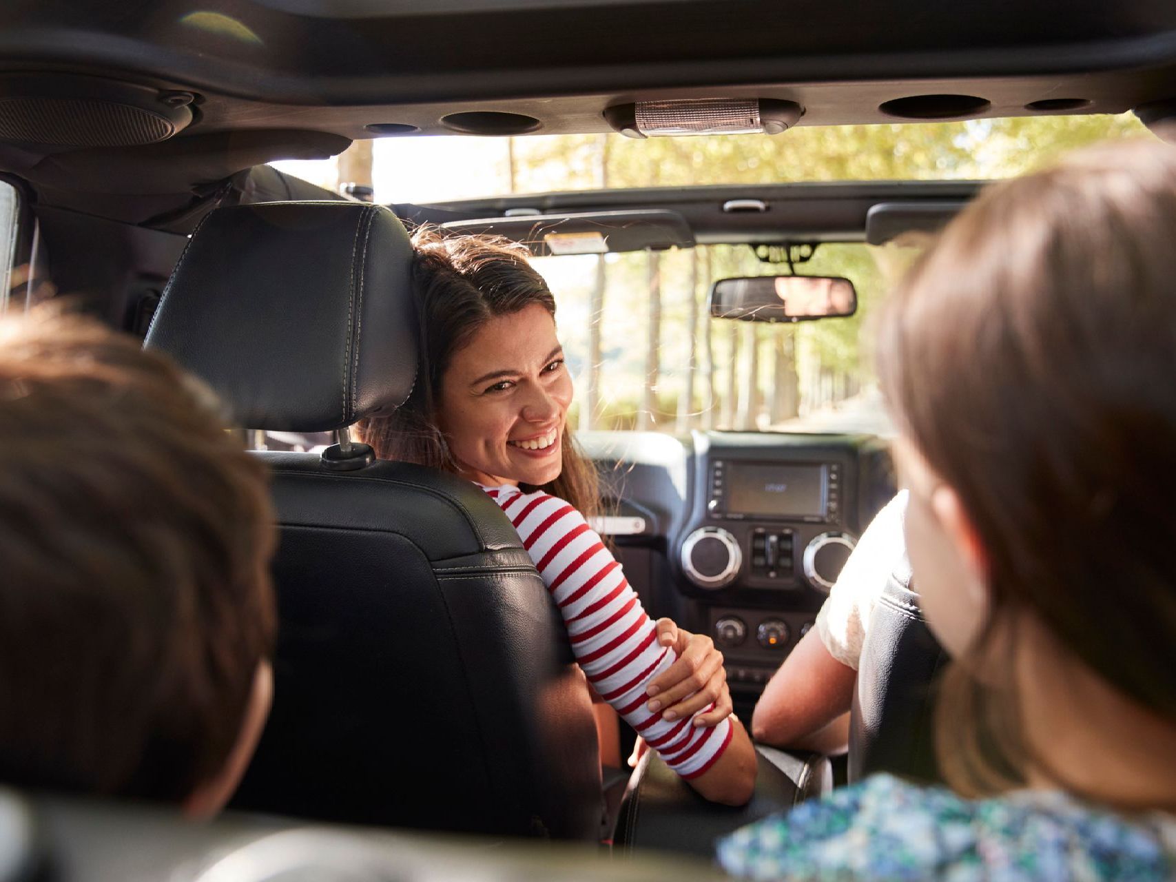 A group of people are sitting in the back seat of a car.