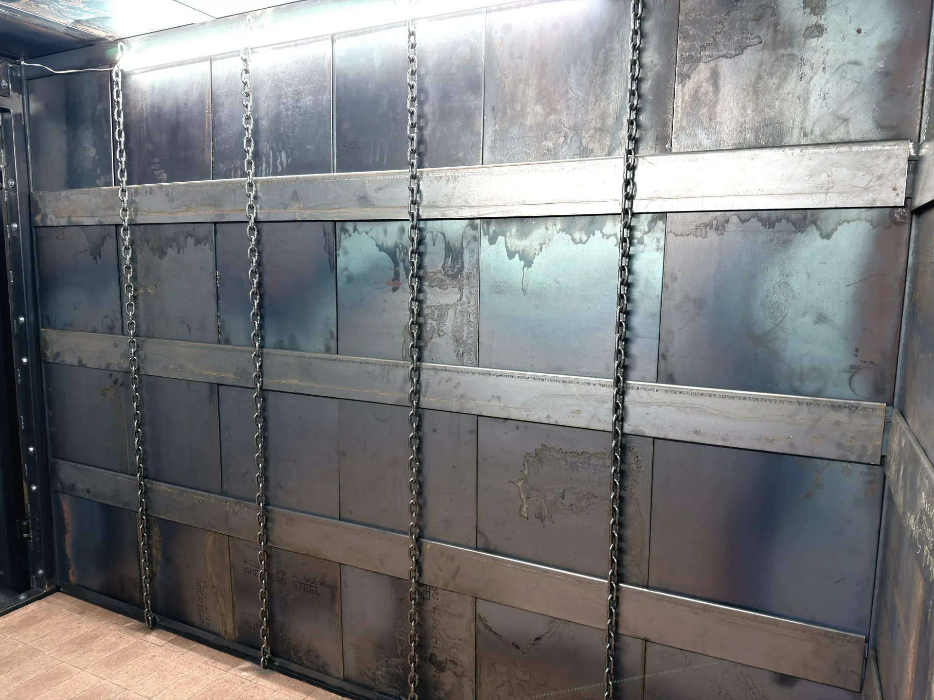 Metal industrial wall panels with riveted seams and a pale blue, worn finish