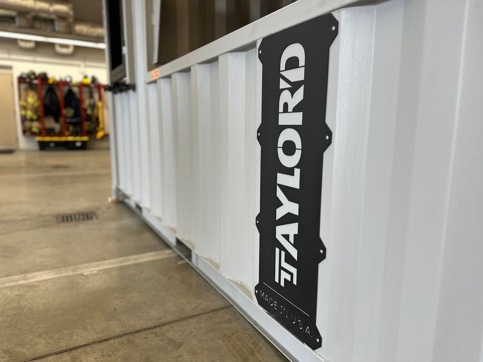 White Taylor-branded equipment case in a store aisle with clothing racks in the background
