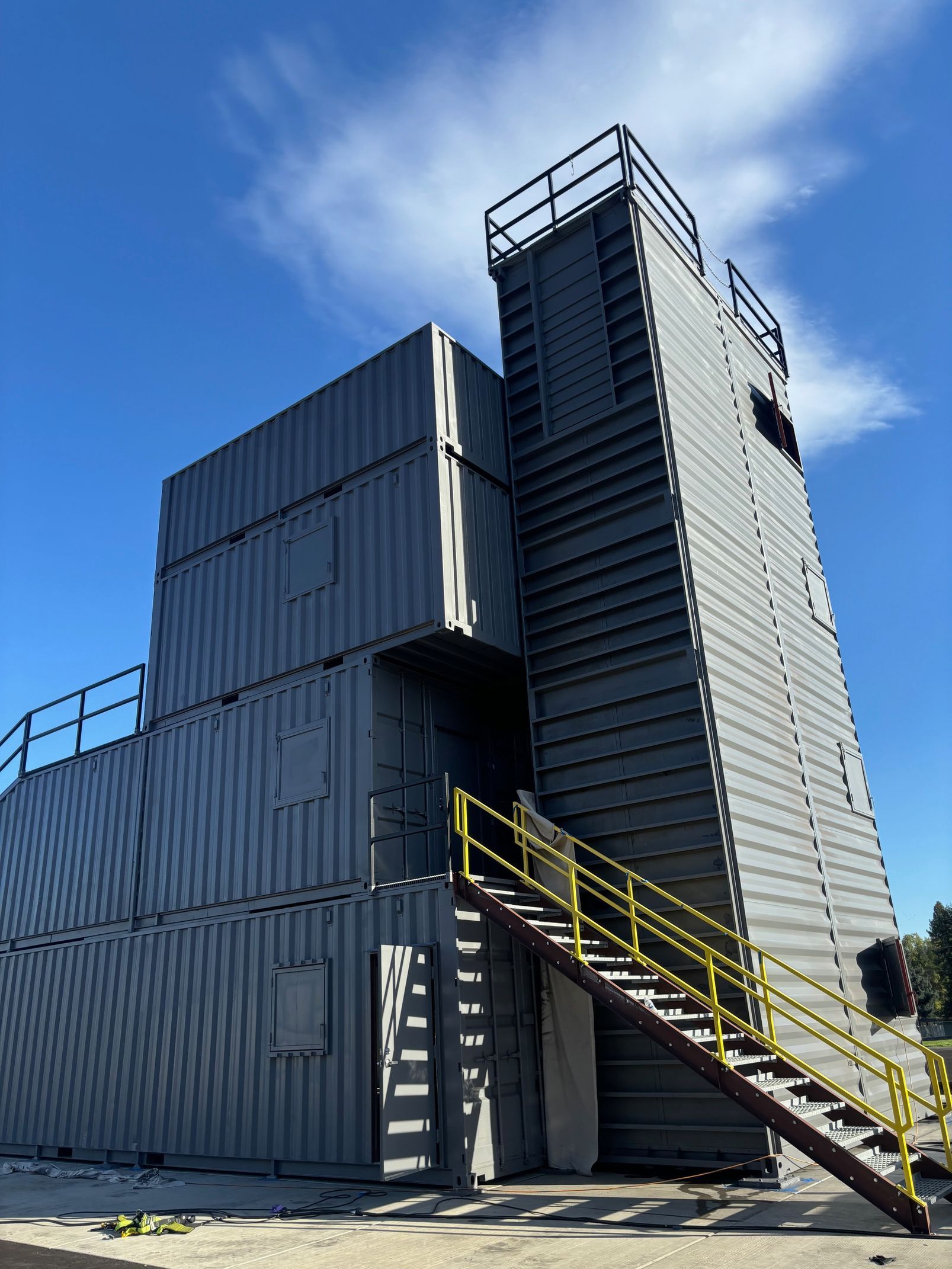 Industrial metal training tower with external stairs under a blue sky