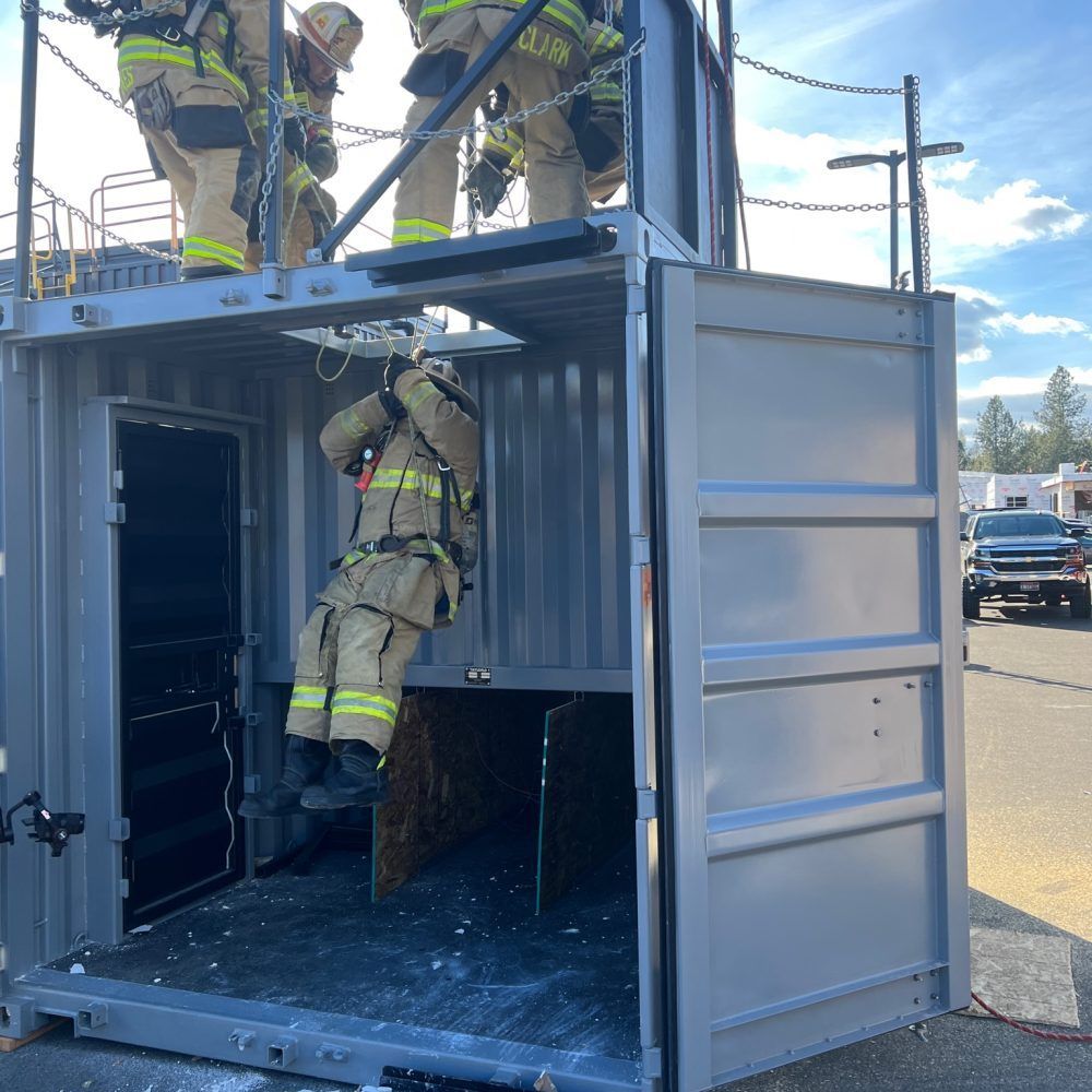 Firefighter climbing into a shipping container during a rescue training exercise