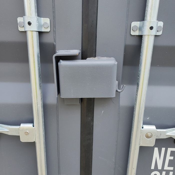 Gray metal gate latch secured between two vertical bars.