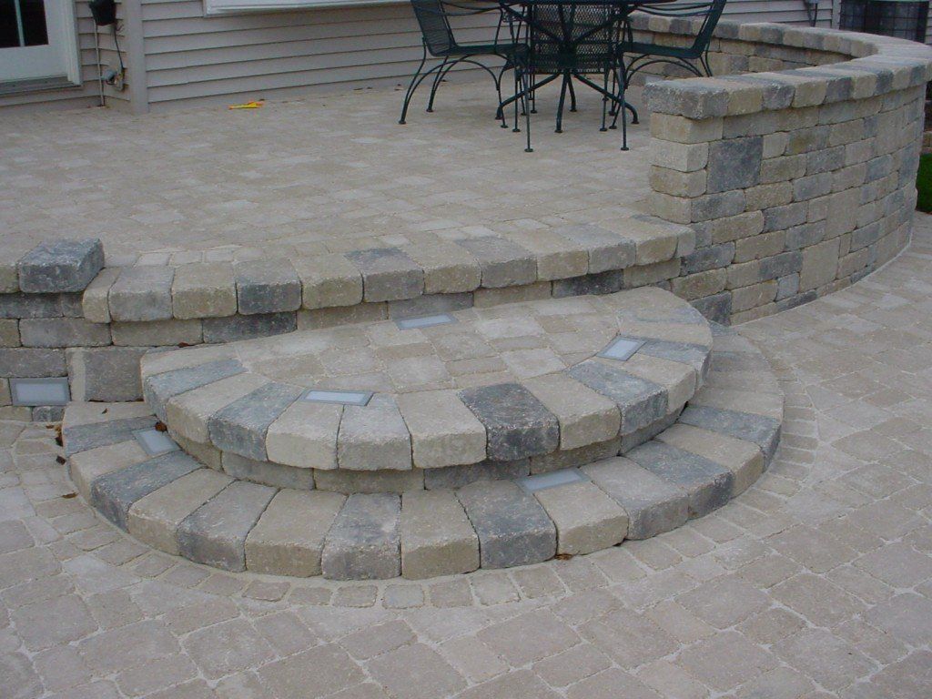 Stone patio with curved steps and low retaining wall.