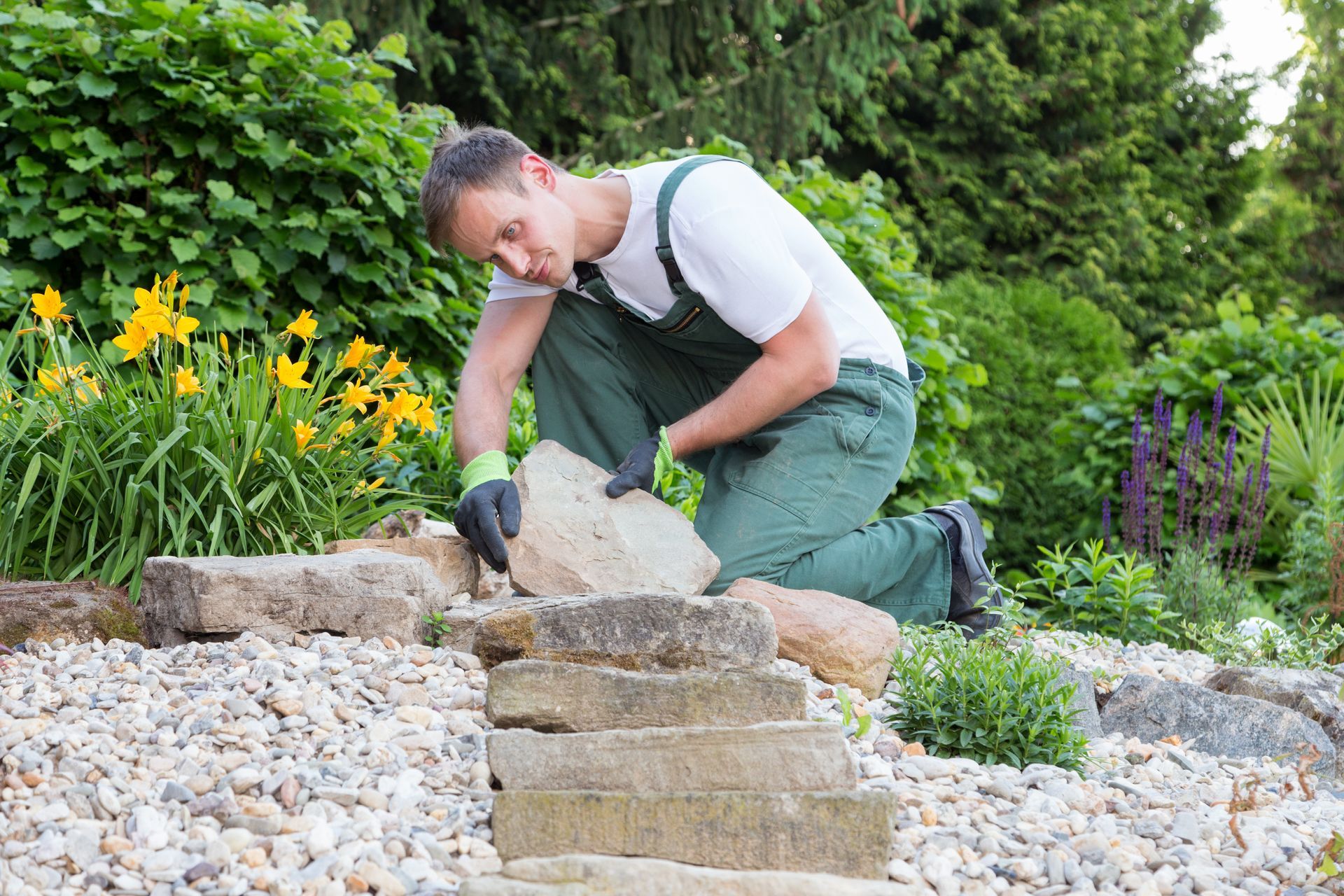 A landscaper is installing a rock garden. A landscaper is installing a rock garden.