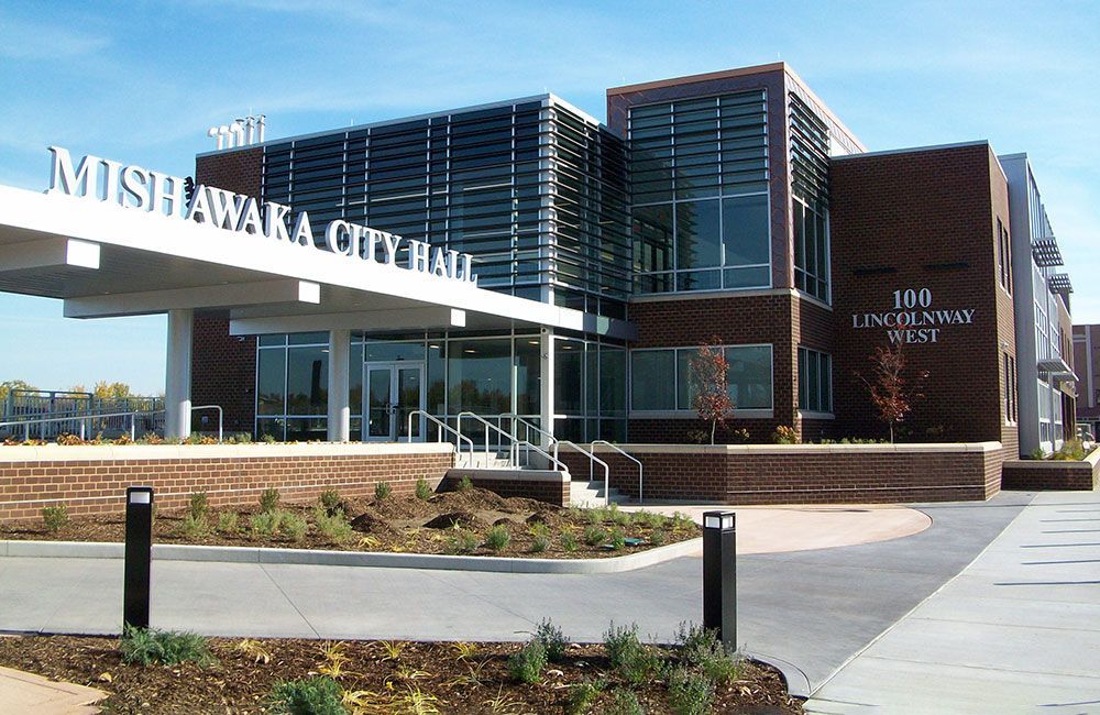 Mishawaka City Hall building featuring a modern brick and glass facade with a prominent white entrance canopy.