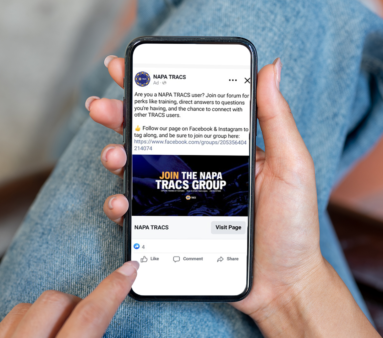 Hands holding a smartphone showing a MAPA TRACS Group social media post and profile page