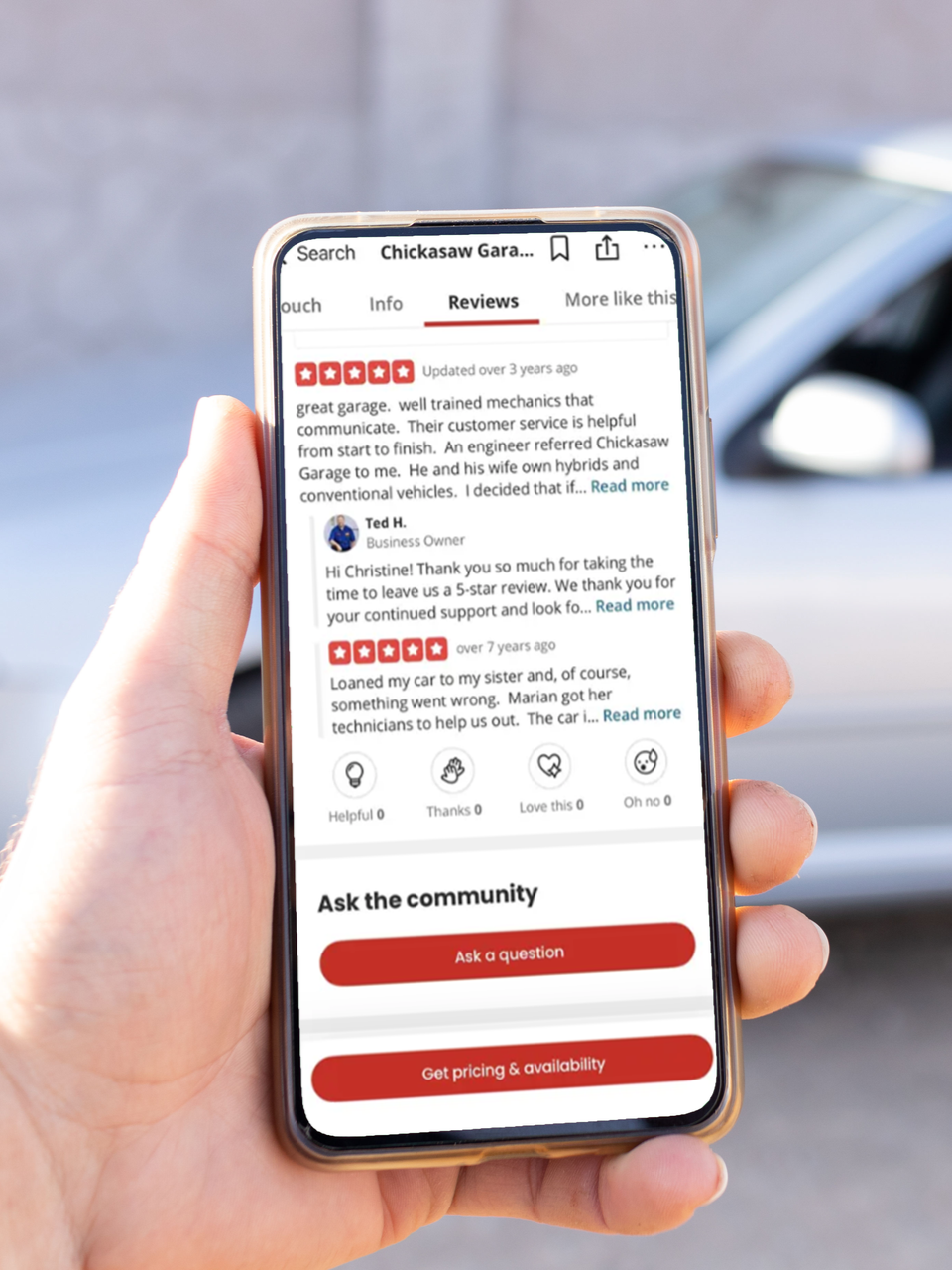 Hand holding a smartphone showing a review page with red rating stars and action buttons